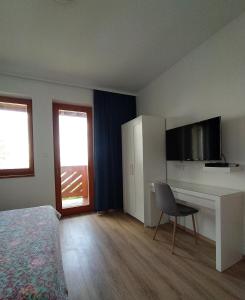 a bedroom with a bed and a desk with a television at Lilla Villa in Siófok