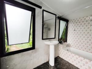 uma casa de banho com um lavatório e uma banheira em ชมวิว รีสอร์ท em Loei