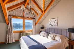 a bedroom with a bed and a large window at Cabañas Puerto Pireo in San Carlos de Bariloche +96 photos