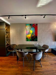 a dining room with a table and chairs and a painting at Aparts Hotel Radom in Radom
