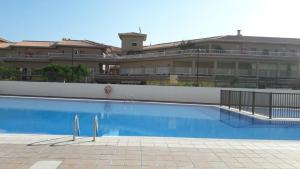 a large swimming pool in front of a building at PLAYA LAS VISTAS LOFT in Los Cristianos