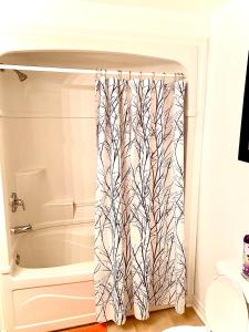 a shower curtain in a bathroom with a bathtub at Centennial Suite in Niagara Falls