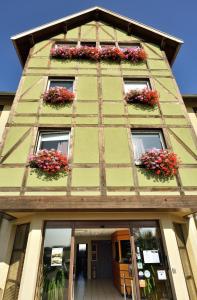 un edificio con ventanas con flores. en Als Hôtel, en Ottmarsheim
