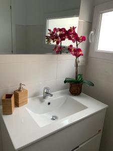 a bathroom sink with a vase of flowers on it at Casa Las Gardenias in Setenil