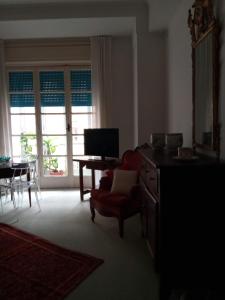 a living room with a television and a table with a chair at Fieschi Inn in Genoa