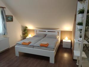 a bedroom with a white bed with two orange towels at Apartmán Frank in Česká Kamenice
