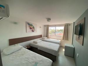 Postel nebo postele na pokoji v ubytování Anjos Praia Hotel