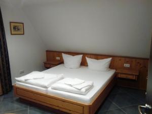 un letto con coperte e cuscini bianchi di Ferienwohnung Harmonie a Kulmbach