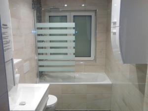 bagno con vasca, servizi igienici e finestra di Ferienwohnung Harmonie a Kulmbach Altre 16 foto