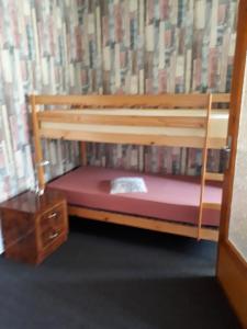 drewniane łóżko piętrowe z czerwonym materacem w obiekcie Ferienhaus Krähmer w mieście Kelbra