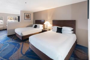 a hotel room with two beds with white sheets at Quality Inn & Suites Kennewick Tri-Cities in Kennewick