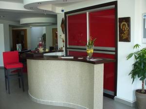 a bar in a room with a red wall at Crystal Aura in Paralia Katerinis