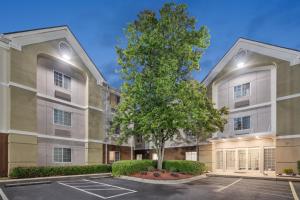 an apartment building with a tree in a parking lot at Candlewood Suites Huntersville-Lake Norman Area, an IHG Hotel in Huntersville