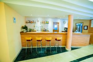 a bar with yellow stools in a room at Hotel Torcal in Guadalajara