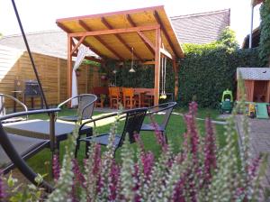 a patio with a table and chairs and purple flowers at Ubytování v soukromí Opolany u Poděbrad in Opolany