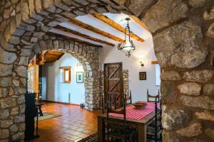 Habitación con un arco de piedra y una mesa. en Masia Pou de la Vinya, en Sitges