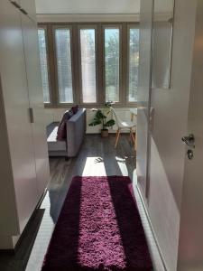 un soggiorno con divano e tappeto rosa di Home Away Center Kuopio a Kuopio