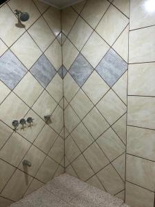 een badkamer met een douche en betegelde muren bij Hospedaje Adrimaran in Palmares