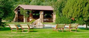 a group of chairs sitting in the grass in front of a house at Hotel Spartivento in Chia