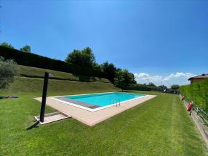 a swimming pool in the middle of a grass field at Casa Vacanze Giacomo Leopardi in Cavaion Veronese