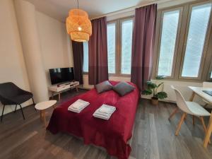 a bedroom with a red bed and a table and chairs at Home Away Center Kuopio in Kuopio