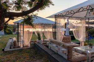 a gazebo with couches and tables in a yard at Prenociste Dunav 97 K3 in Novi Banovci