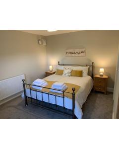 a bedroom with a large bed with two night stands at The Woad Mill in Boston