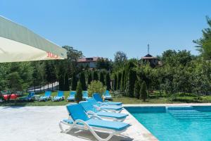 a row of blue lounge chairs next to a swimming pool at Casa Știuca Șchioapă in Băltenii de Sus
