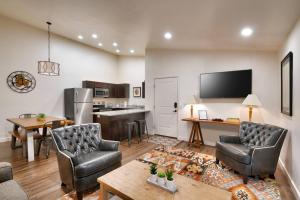 uma sala de estar com cadeiras e uma mesa e uma cozinha em 5K Top Floor RedCliff Condo, Pool & Hot Tub em Moab