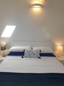 a bedroom with a large white bed with two lamps at Cottage al mare Martina in Venice-Lido