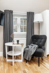 a living room with a chair and a table at Ludvika Stadshotell in Ludvika