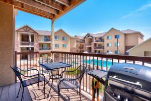 a balcony with tables and chairs and a grill at 6B Cozy Moab RedCliff Condo, Pool & Hot Tub in Moab