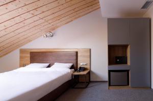 モスクワにあるTurris Hotel Taganskyのベッドルーム1室(大型ベッド1台、木製ヘッドボード付)