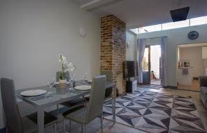 a dining table and chairs in a living room at Beautiful river balcony cottage in heart of historic sandwich in Kent