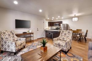 a living room with two chairs and a table and a kitchen at 6H Spacious RedCliff Condo, Pool & Hot Tub in Moab