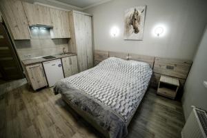 ein kleines Schlafzimmer mit einem Bett und einer Küche in der Unterkunft Veronika in Poljana