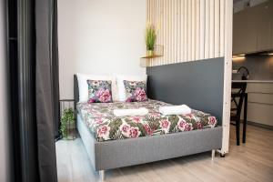 EASY RENT Apartments - BUSINESS CENTER 41 في لوبلين: غرفة نوم مع سرير مع أوراق ومخدات من الزهور