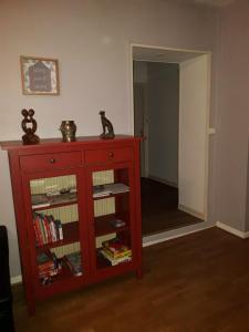 ein roter Schrank mit Büchern auf einem Zimmer in der Unterkunft Appartement 80m2 dans belle demeure in Vrigne-aux-Bois