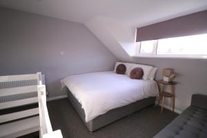 a small bedroom with a white bed and a window at Amaya Four - Newly renovated and very well equipped - Grantham in Grantham
