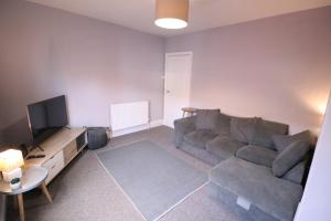 a living room with a couch and a television at Amaya Four - Newly renovated and very well equipped - Grantham in Grantham