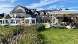 a large house with white gazebos in a yard at Apartamenty Faltom in Swarzewo