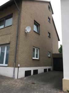 ein Backsteingebäude mit einem Satelliten an der Seite in der Unterkunft H&E Apartments Barntrup in Barntrup