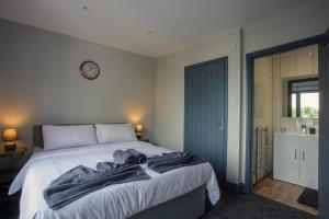 1 dormitorio con 1 cama y reloj en la pared en Beautiful river balcony cottage in heart of historic sandwich, en Kent