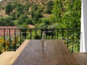 a glass of water sitting on a wooden table on a balcony at VILA RIRA - Rrajcë, Shebenik in Përrenjas