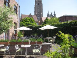 an outdoor patio with tables, chairs, and umbrellas at Bonobo Apartments in Bruges