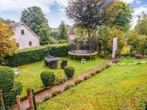 um jardim com uma mesa e um trampolim em Tranquil Holiday Home with Private Garden em Krinkelt