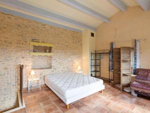 a bedroom with a bed and a chair in it at Heritage Villa in Les Mages with Swimming Pool in Les Mages