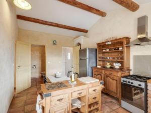 a large kitchen with wooden cabinets and a refrigerator at Heritage Villa in Les Mages with Swimming Pool in Les Mages