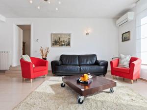 ComerioにあるBelvilla by OYO Varese Treのリビングルーム(黒い革張りのソファ、赤い椅子2脚付)