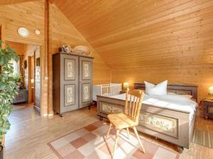 a bedroom with a bed and a chair in a room at Chalet in Hinterrod Thuringia with sauna in Eisfeld